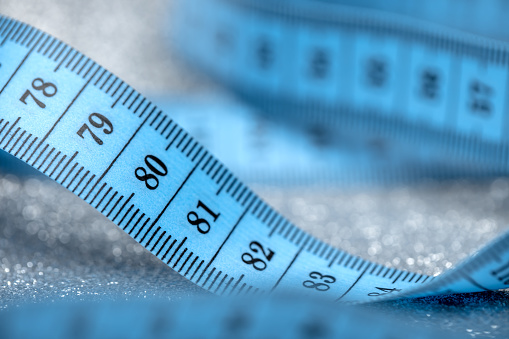 Close-up of tape measure on a sparkling background. Shallow depth of field.
