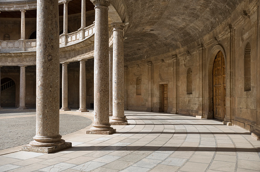 An interior view of The Palace of Charles V showing massive support columns, located within the Alhambra in Granada, Spain 
