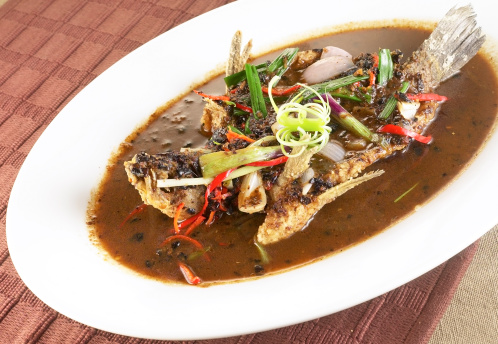 Asian style whole fish. Garnished with spring onions and a healthy splash of fish soy sauce