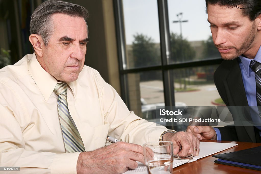 Gut gekleideten Mann ausfüllen Dokument mit einem kleinen Person - Lizenzfrei 60-69 Jahre Stock-Foto