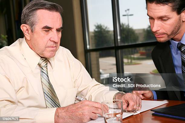 Gut Gekleideten Mann Ausfüllen Dokument Mit Einem Kleinen Person Stockfoto und mehr Bilder von 60-69 Jahre