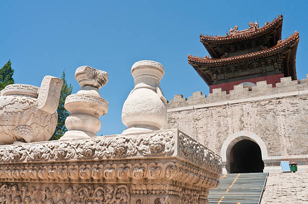 White marble urns in front of the steep stairs and tiled pagoda roof of a traditional Qing Dynasty Chinese temple north of Beijing under clear blue summer skies. ProPhoto RGB profile for maximum color fidelity and gamut.