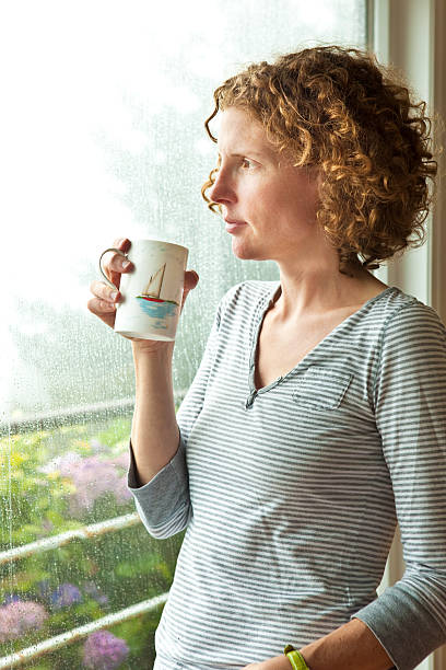 istock Content woman drinking coffee and looking out window waiting 176047743