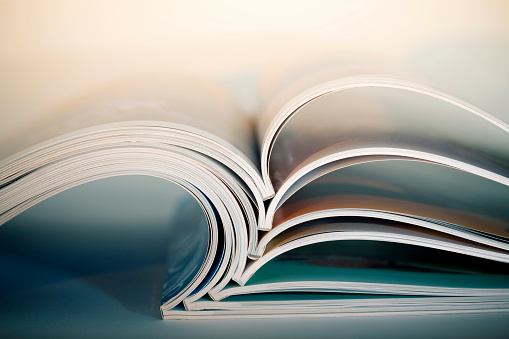 Abstract shot of open magazines stackon table. Macro shot with shallow DOF