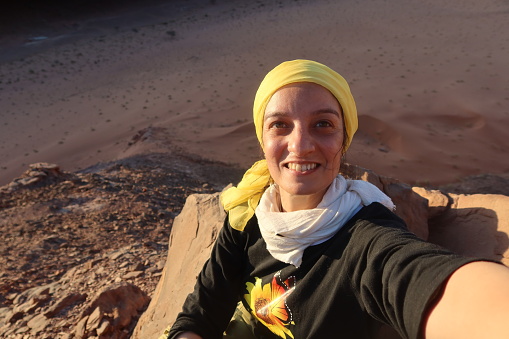 A cheerful woman taking selfie on top of Serabit mountain in Saini