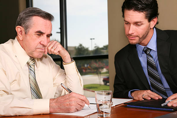istock Senior Businessman Looking over documents with younger co-worker 176048848