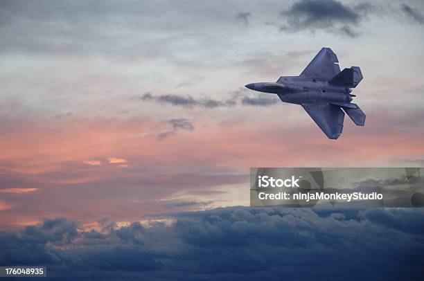A F22 Fighter Jet Flying Through Clouds In A Colorful Sky Stock Photo - Download Image Now