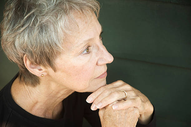 istock Senior woman with hands together on chin while thinking 176049029