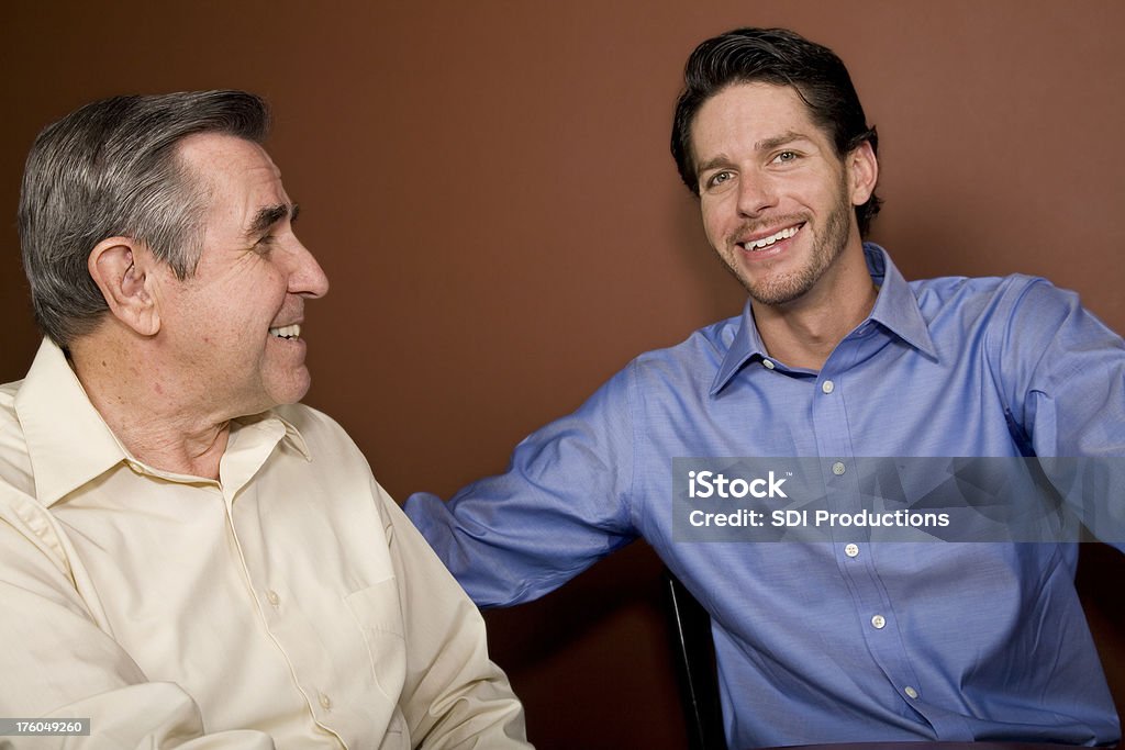 Père et fils assis dans la Discussion - Photo de 65-69 ans libre de droits