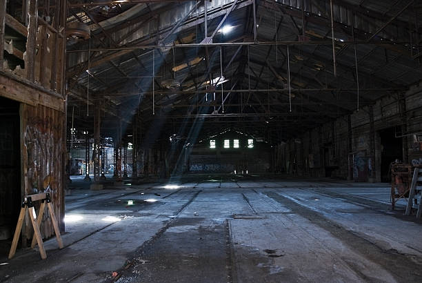 istock Abandoned warehouse with sun peeking through roof 176049405