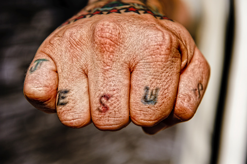 a jesus tattoo / emblazoned on the knuckles / represents the faith