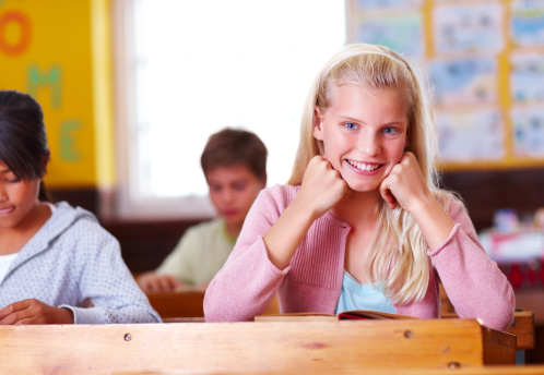 Portrait of a schoolgirl smiling in classroom