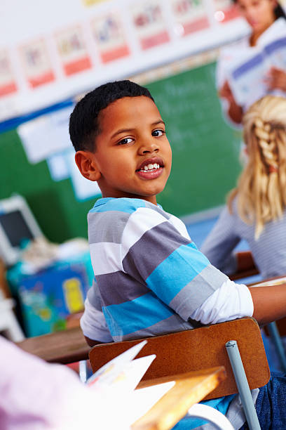 istock Portrait of a schoolboy looking behind in classroom 176049968