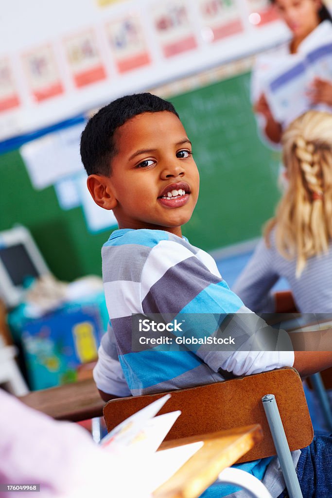 Retrato de um aluno olhando para trás em sala de aula - Foto de stock de 8-9 Anos royalty-free