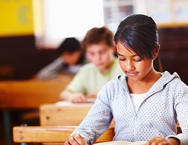 istock Schoolgirl reading book 176049969