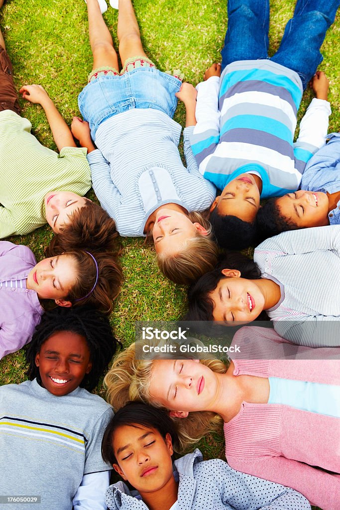 Vue plongeante de jeunes enfants, allongé sur l'herbe - Photo de 10-11 ans libre de droits