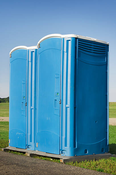 istock Two Blue Portable Toilets Outdoors Under Clear Sky in Summer 176050060