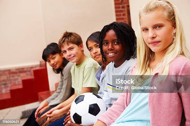 Foto de Meninos E Meninas Sentada Com De Futebol e mais fotos de stock de 10-11 Anos - 10-11 Anos, 12-13 Anos, Afro-americano