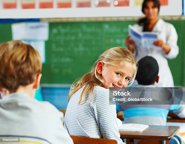 Portrait Of A Schoolgirl Looking Behind And Smiling Stock Photo - Download Image Now