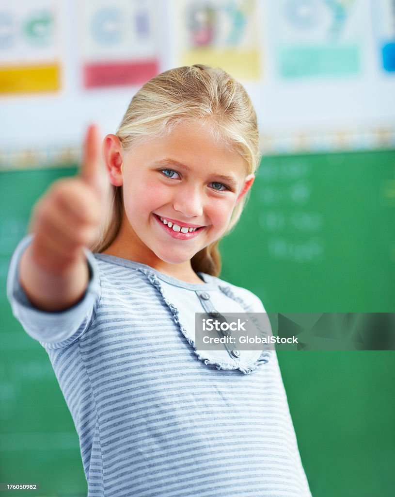 Ritratto di un giovane studentessa mostrando pollice in alto - Foto stock royalty-free di Bambino di scuola elementare