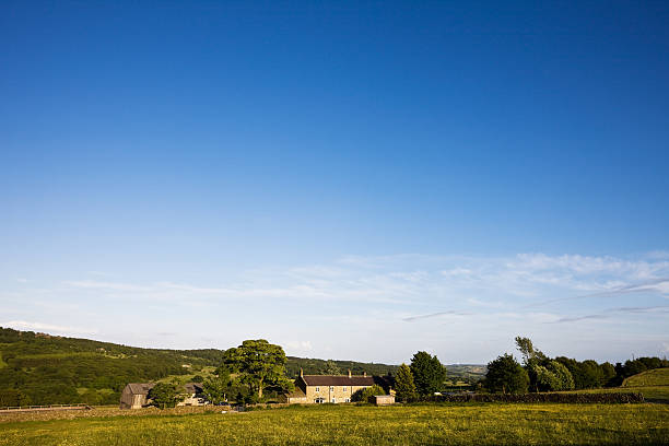Aerial view of beautiful agricultural fields with cloudy blue sky in England