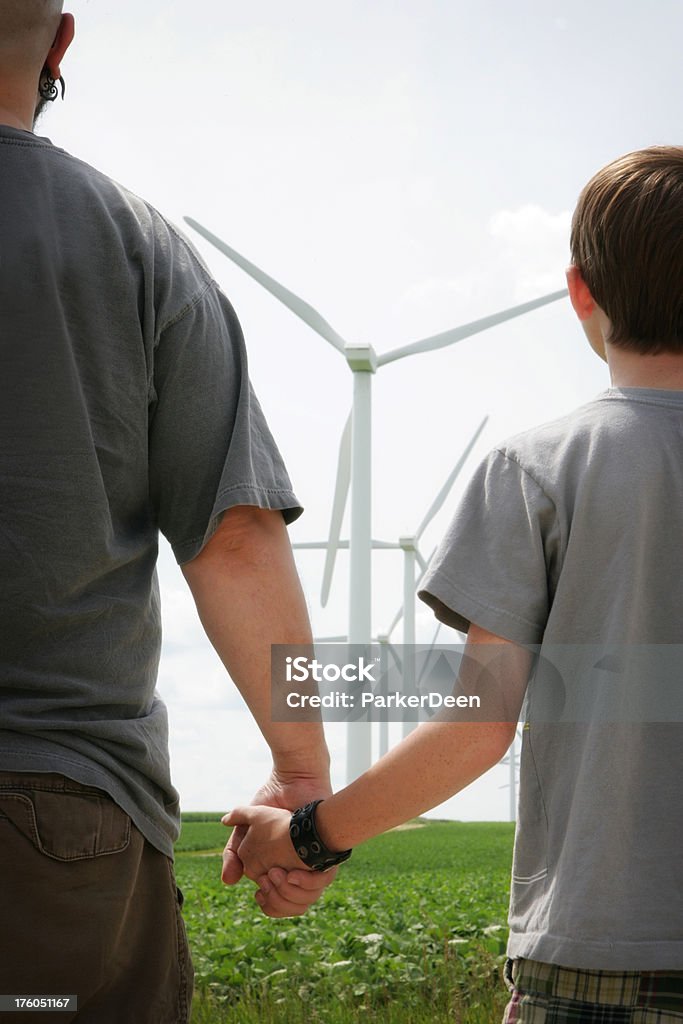 Energia renovável Generations- homem e criança Veja os moinhos de vento - Foto de stock de Eletricidade royalty-free