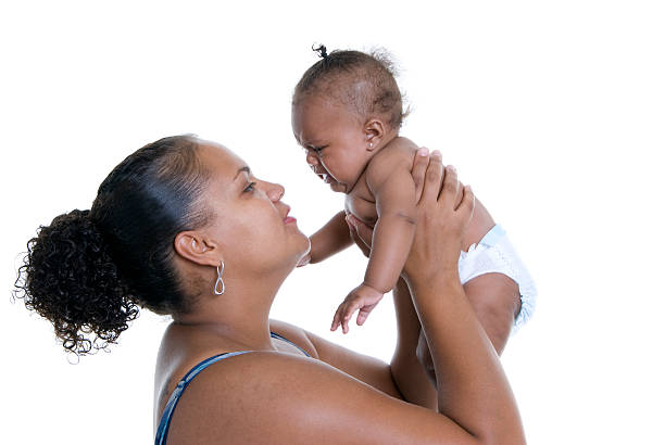 Mother holding her baby above her.
