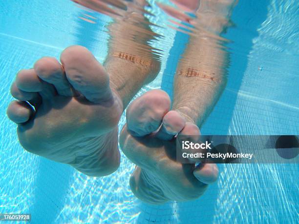 Photo libre de droit de Les Pieds Nus Immergés Dans La Piscine Bleue banque d'images et plus d'images libres de droit de Adulte - Adulte, Bleu, Eau