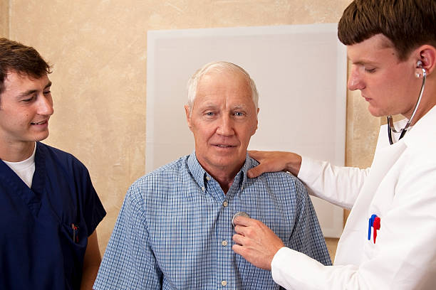 Senior adult having medical exam with doctor and male nurse. Senior adult having medical exam. male nurse male healthcare and medicine technician stock pictures, royalty-free photos & images