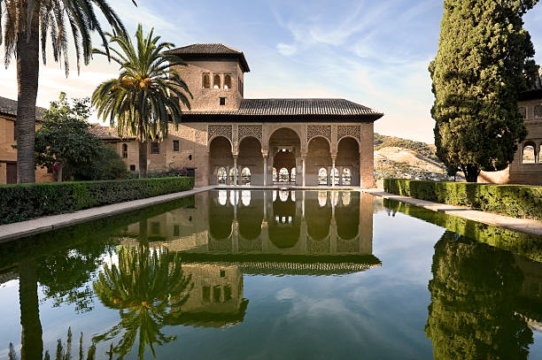 Alhambra Palace with perfect reflection in Granada, Spain A view of an ancient palace at sunset at the Alhambra in Spain. A perfect mirrored reflection. granada stock pictures, royalty-free photos & images