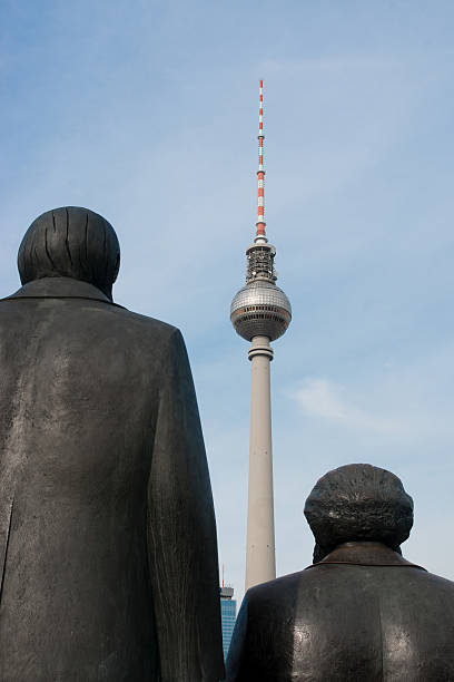 View to the Berlin Radio Tower with the backs of the memorial statues of Karl Marx and Friedrich Engels in the public place Marx-Engels-Forum