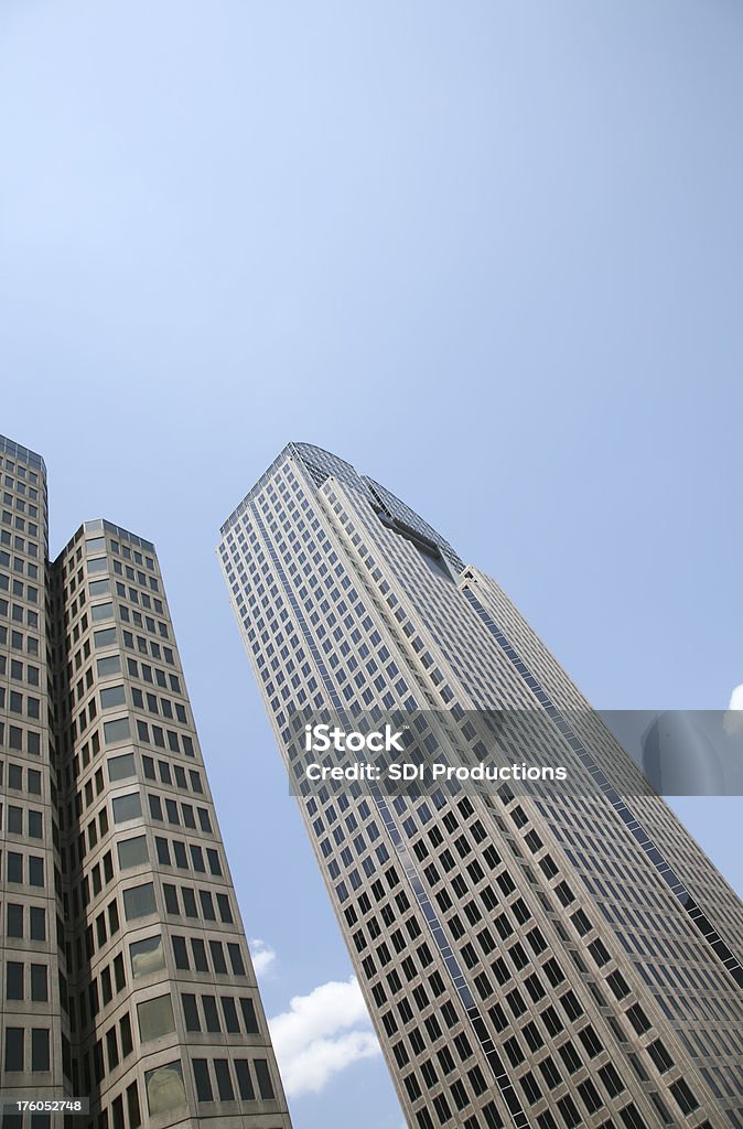 Vista basso angolo di grattacieli contro un cielo azzurro - Foto stock royalty-free di Affari