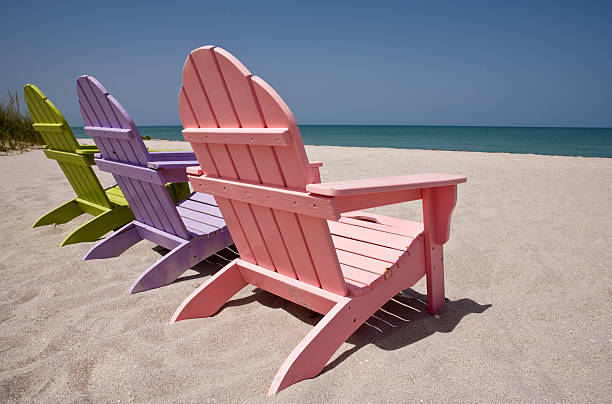 istock Close up of three pastel colored beach chairs on sand 176052940