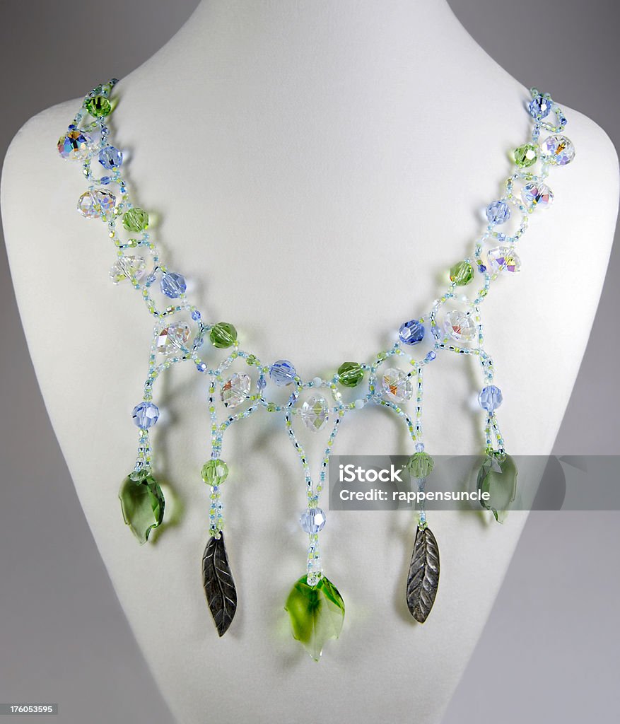 Colorful necklace on white velvet Image of a colorful hand crafted beaded necklace draped around a white velvet display. Jewelry Stock Photo