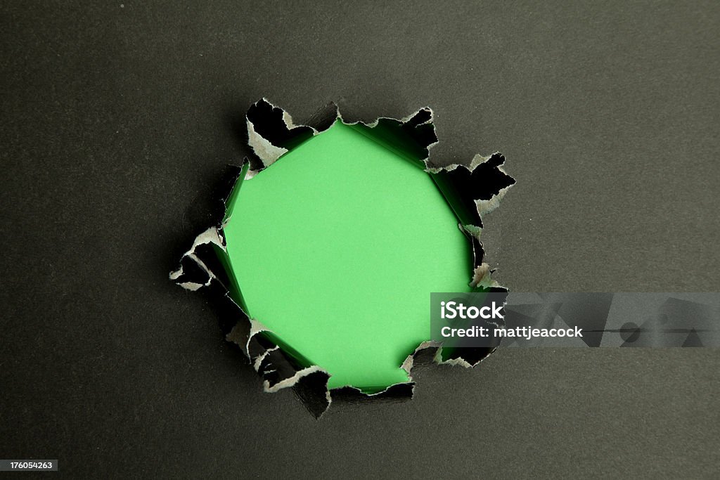 Отверстия в бумаге с черный с зеленый фон за его - Стоковые фото Абстрактный роялти-фри