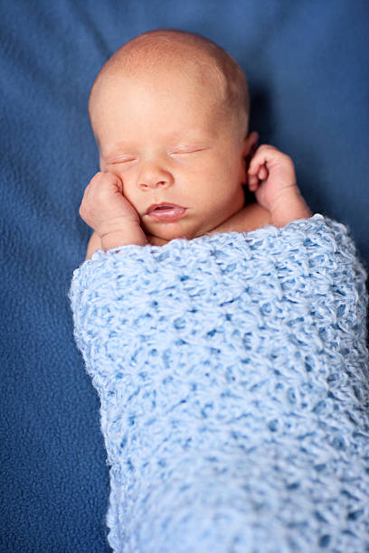 istock Newborn Baby Boy Sleeping Peacefully in Blanket 176054307