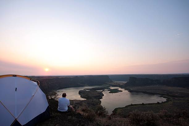 キャンパーながら、日の出を眺めるのにドライ - tent camping dome tent single object ストックフォトと画像
