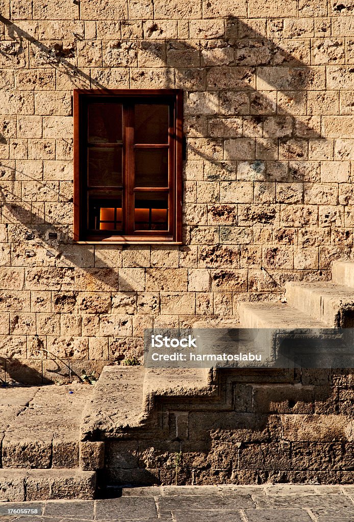 Old brick wall "Old brick wall with window and stairs in the old town of Rhodes city on Rhodes island, Greece. Warm white balance." Abstract Stock Photo
