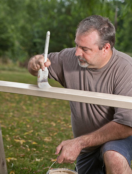 istock mid age man outdoors painting railing 176056436