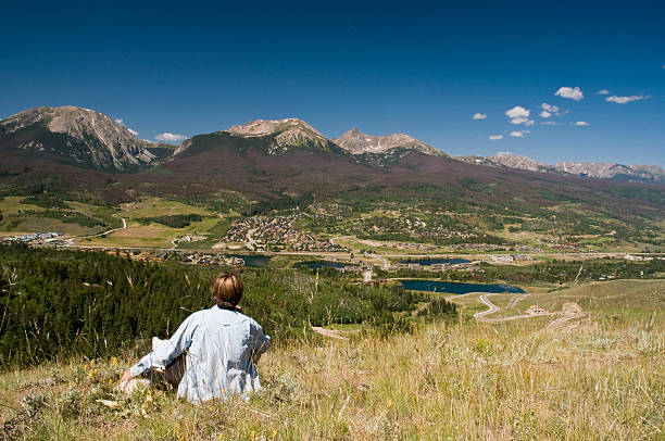 Woman Hiker and Her Dog Enjoying the View A woman hiker and her dog take a break from a hike and enjoy the view of a mountaing range across the valley. summit county stock pictures, royalty-free photos & images