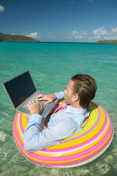 istock Businessman Sits Floating and Typing in Rubber Ring 176056789