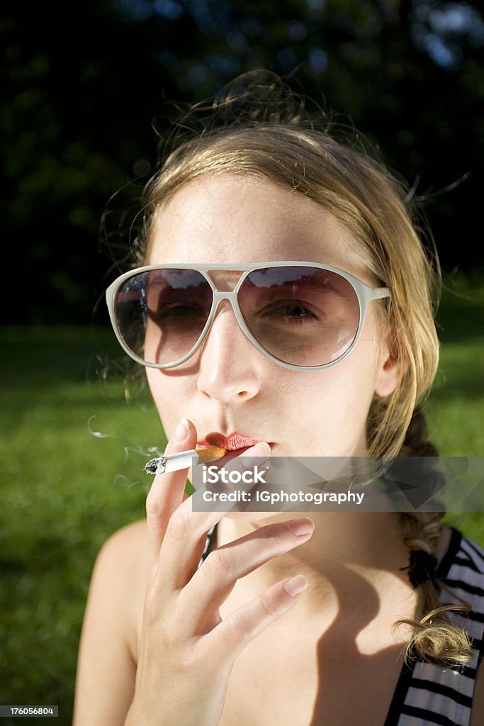 Atraente Jovem mulher fumar um cigarro com óculos de sol - Foto de stock de 1950-1959 royalty-free