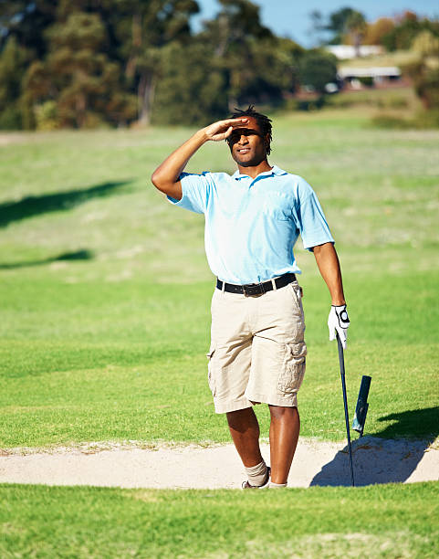 Golfer searching for the ball after a shot from a sand bunker