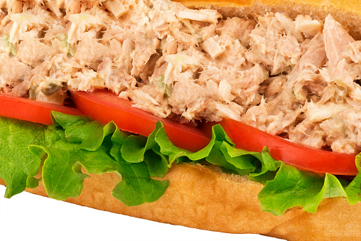 Close up of submarine tuna sandwich on white background. Macro photography for texture.