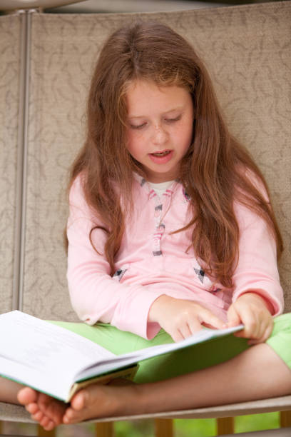 istock girl sit on seesaw and reading the book 176059154