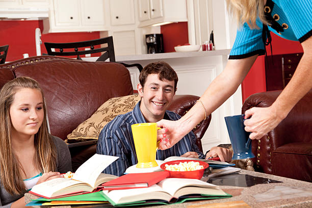 istock Teenagers on floor in living room doing homework 176059574