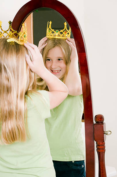 istock Young Girl Tries on Crown Looking in Mirror 176060587