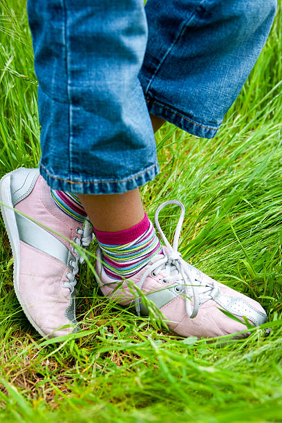 close -up of の小さな女の子の靴の緑の芝生 - children only healthy lifestyle vertical close up ストックフォトと画像