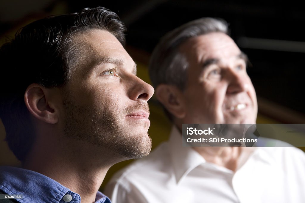 Dois homens olhando para cima com luz brilhante sobre eles - Foto de stock de 60 Anos royalty-free