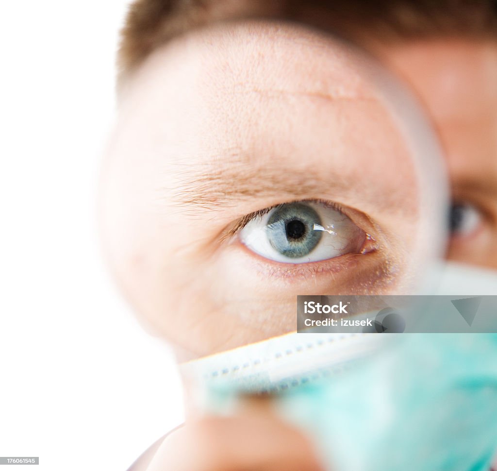 Human Eye Magnified, Male Doctor A male doctor looking at camera through a magnifying glass. Focus on the eye. Doctor Stock Photo